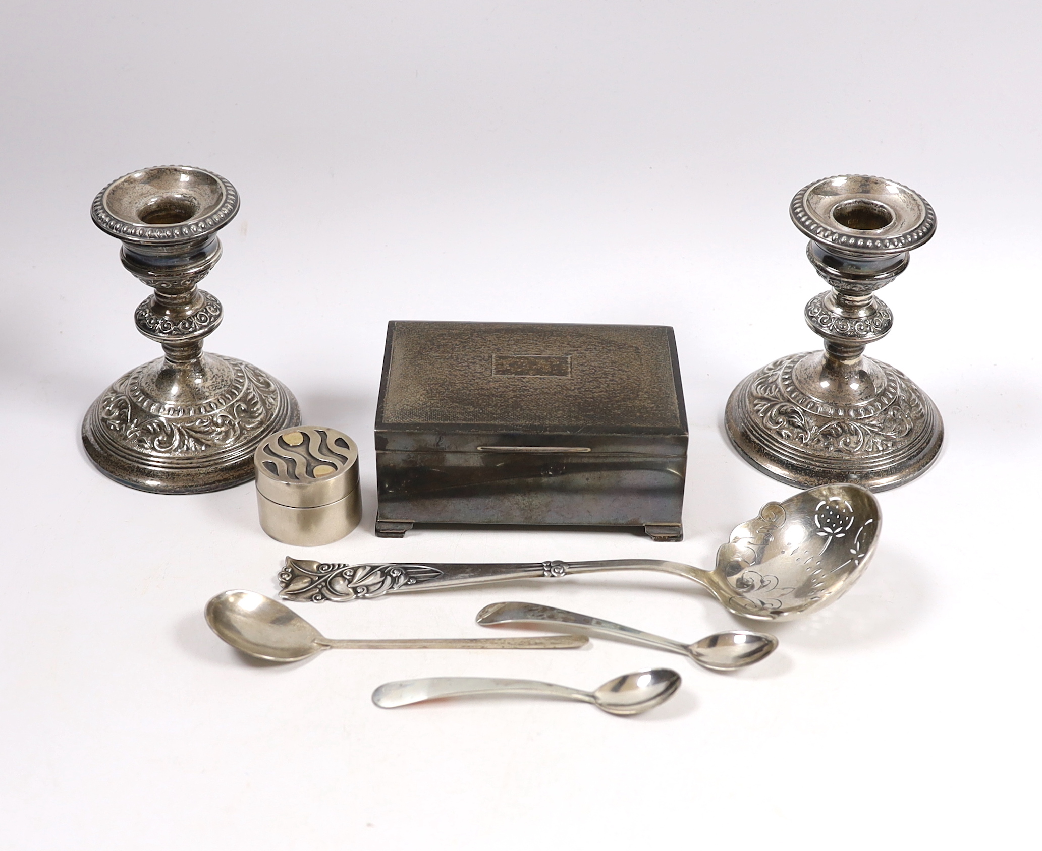 Sundry silver including a cigarette box, pair of dwarf candlesticks, modern silver circular pill box and three spoons, maker GR and a large early 20th century stylish Swedish white metal sifter ladle.